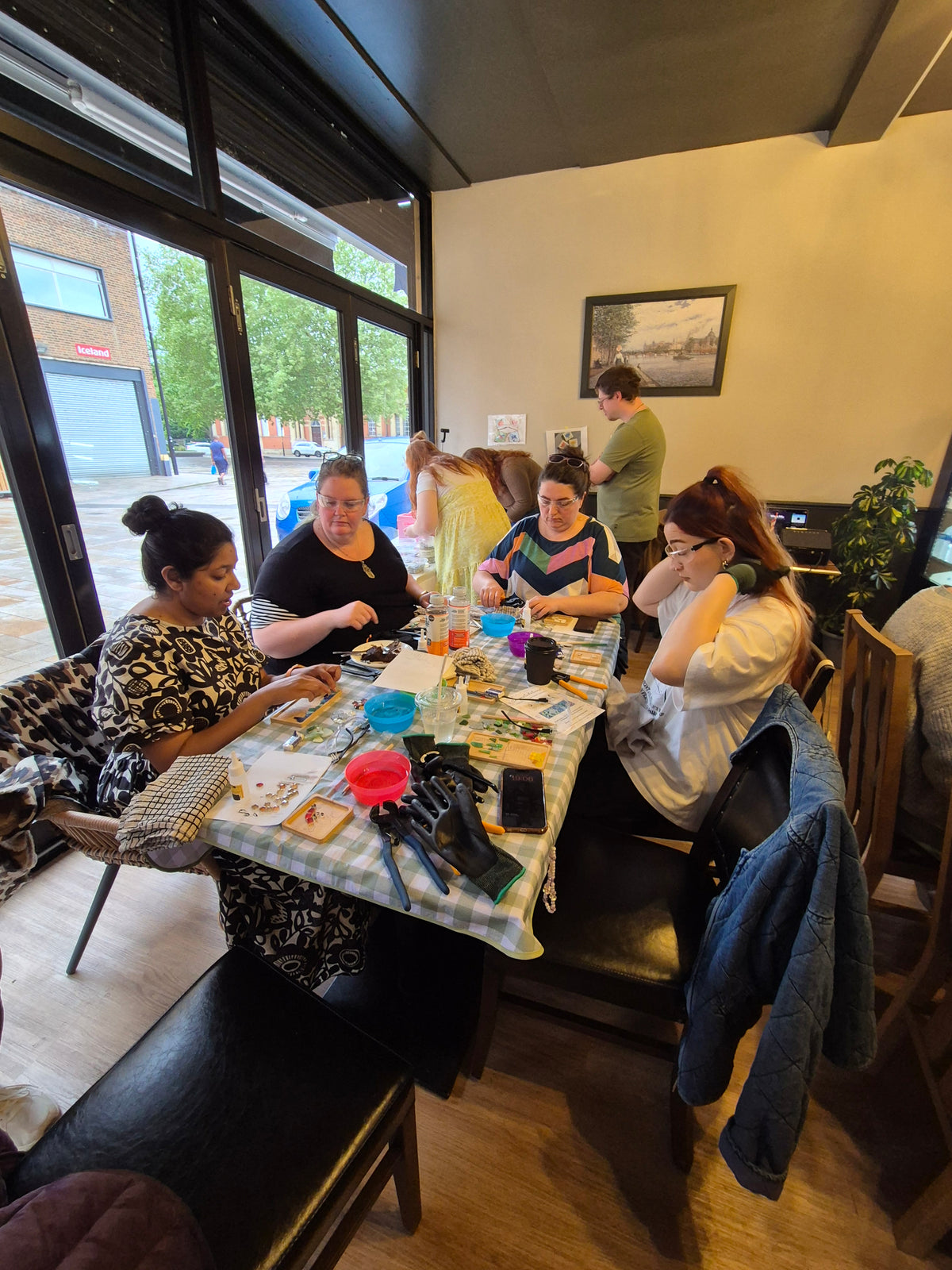 People gathered around a table with a colorful tablecloth in a casual setting.